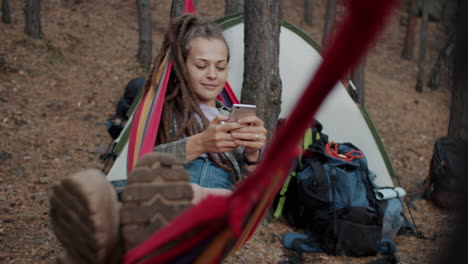 woman relaxing in hammock at camping site
