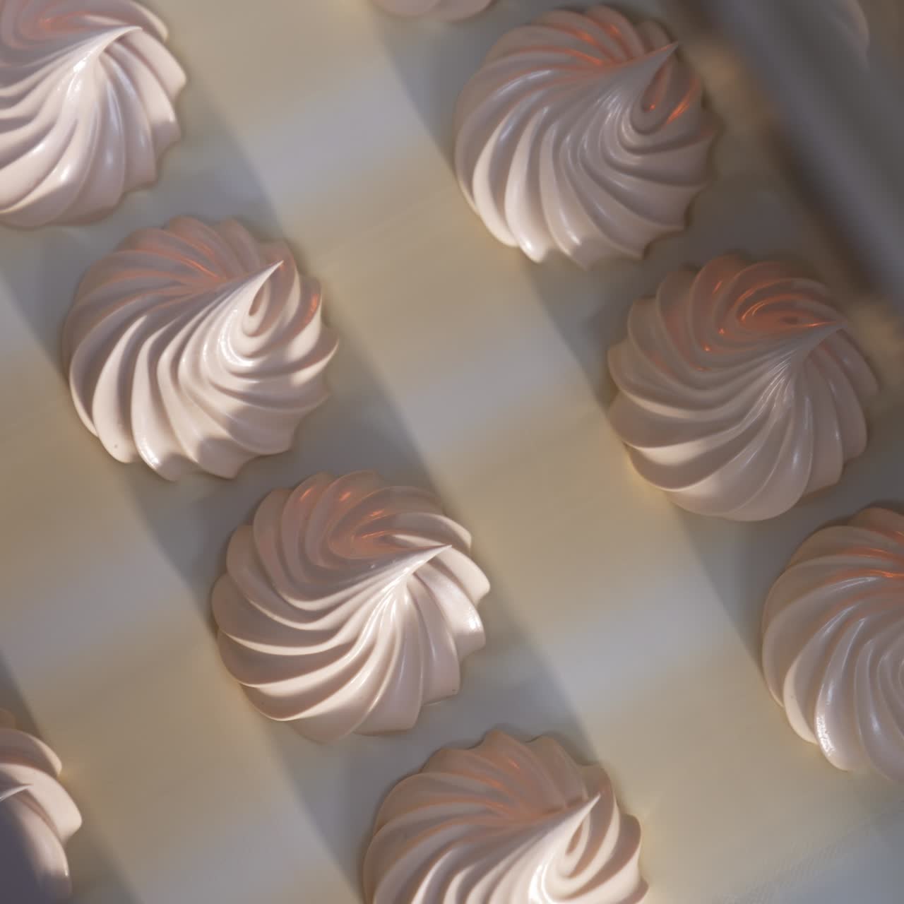Beautiful creamy vanilla marshmallows come from a machine. Conveyor belt with fresh zephyr desserts. Close up. Top view