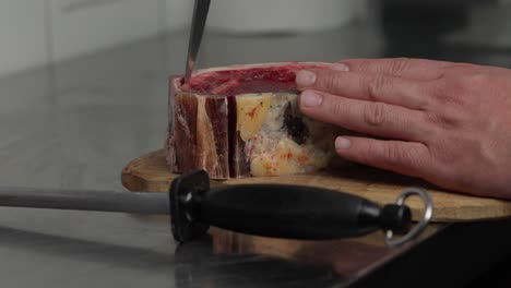 cook preparing barbecue steak with a sharp knife