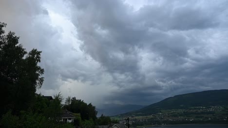 triple lightning bursts erupt over voss with storm clouds above vangsvatnet lake and mountains in dramatic summer weather