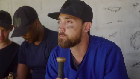jugador de béisbol mirando lejos en el vestuario