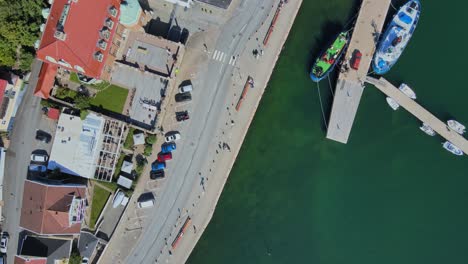 seaside road with boats moored on jetty by clear blue sea in lysekil, sweden