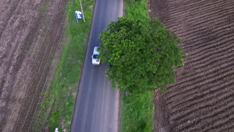 fotografía aérea, mirando hacia abajo siguiendo un coche en una carretera de asfalto, cerca del barrio de el castillo, en valle del cauca
