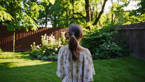 young girl walking in a sunny backyard garden