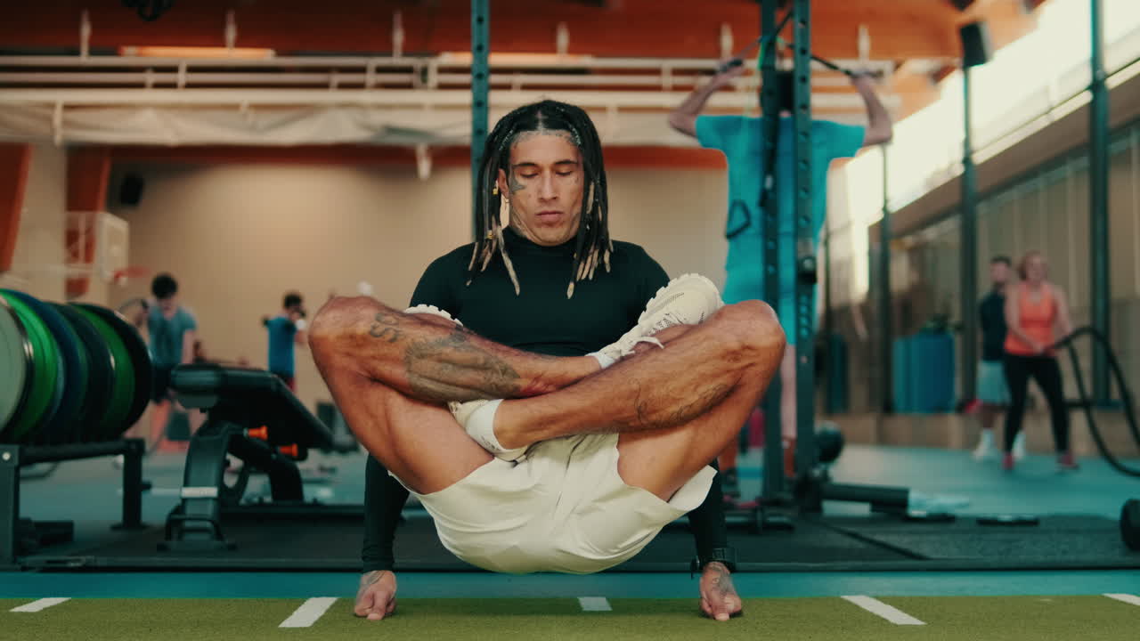 Athletic Man with Dreadlocks Performing Advanced Yoga Pose in Gym