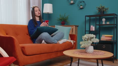 una joven triste usa su teléfono móvil, navega, pierde, se sorprende repentinamente de los malos resultados de la lotería.
