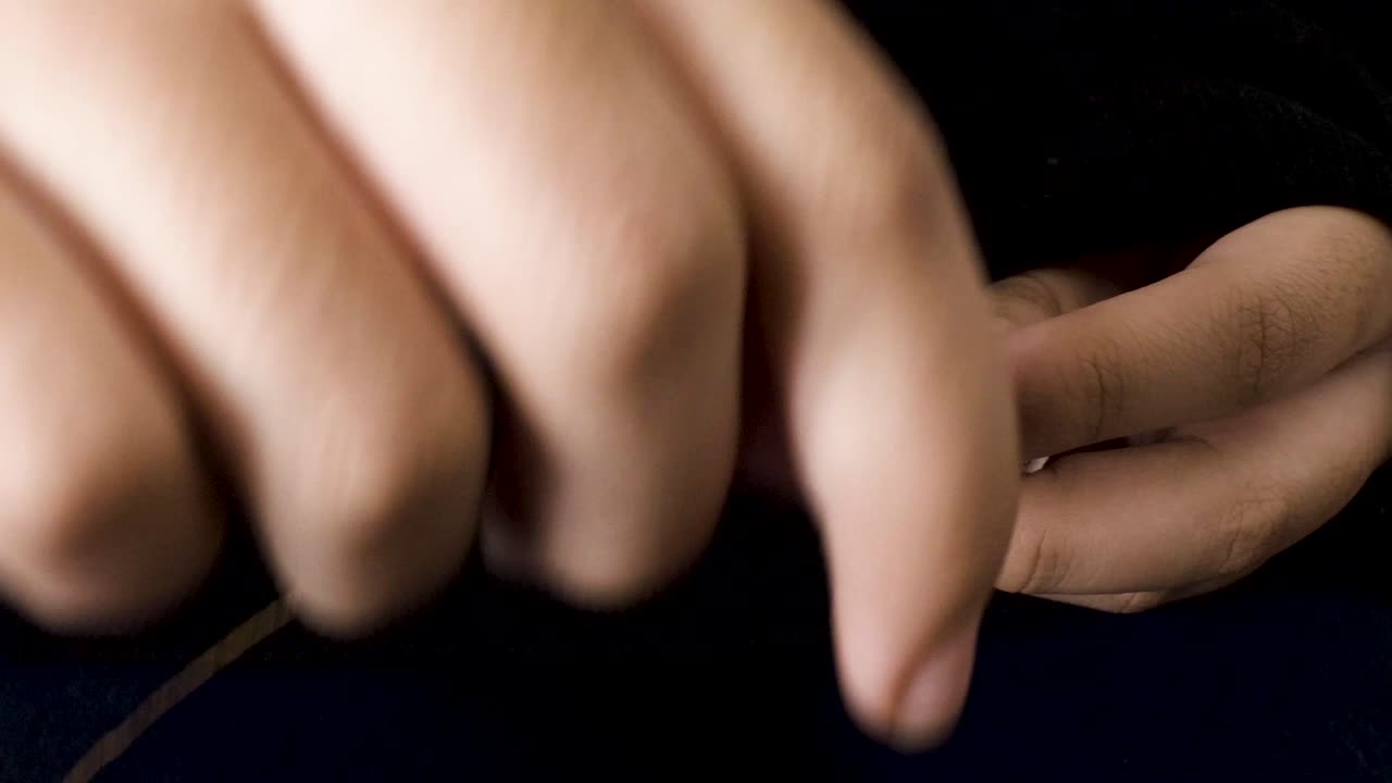 양손으로 실패에 갈색 재봉사 감기