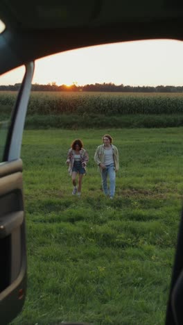 couple exploring a field at sunset