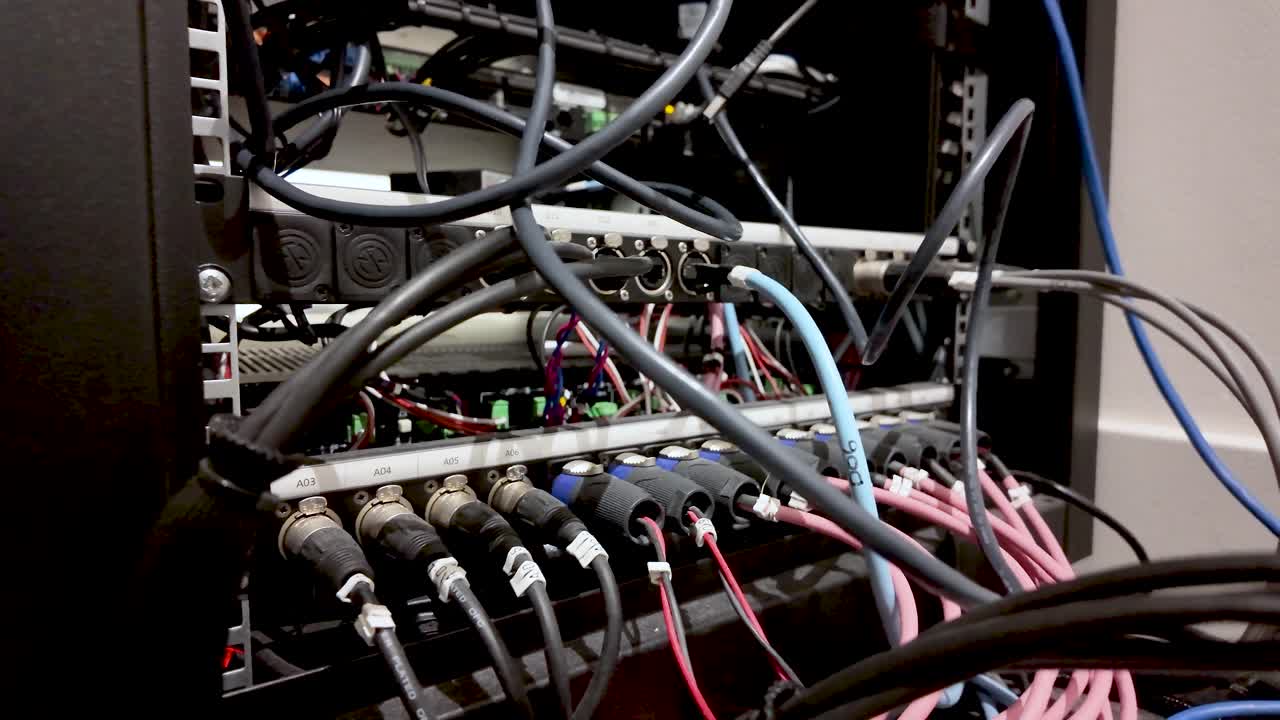 Audio visual rack with interconnected XLR cables and wiring, showing data and power connections