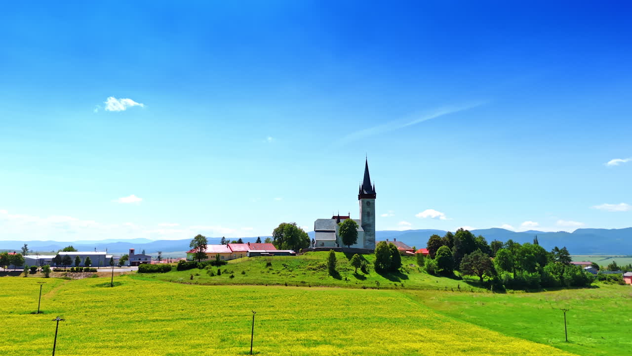 Old church on the hill surrounded by trees and lovely lawn. Lovely countryside on sunny summer day in Slovakia