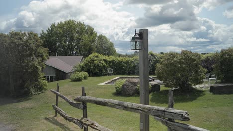 Walking-down-a-wood-fence-line-on-a-gravel-road-to-reveal-a-beautiful-farm-house-mansion-and-a-elegant-water-fountain-feature-on-the-acreage-at-the-Strathmere-Wedding-and-Event-Centre