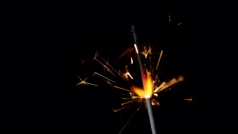 Bengal-fire,-New-Year-sparkler-candle,-sparkling-lights-burning-on-a-black-background,-slow-motion