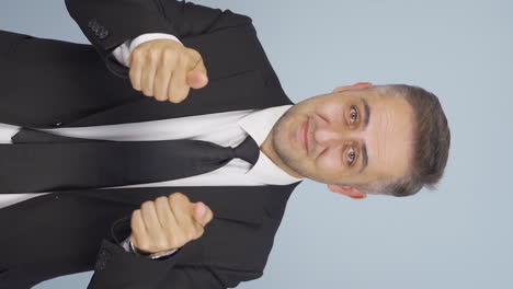 vertical video of businessman making a trust sign at the camera.