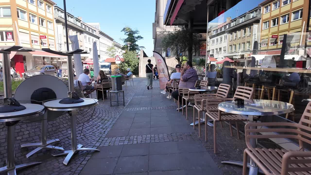 Walking Darmstadt streets, coffee shop with people sitting and morning sun reflecting in window, Hessen, Germany