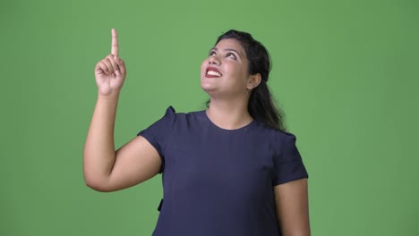 joven sobrepeso hermosa mujer de negocios india contra fondo verde