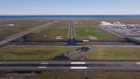 keflavik international airport in iceland on sunny day, airplane taxiing, aerial shot