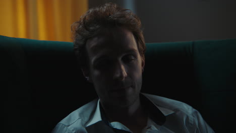 Man Sitting in a Dark Room