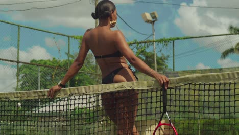 a thong bikini-clad young girl enjoying a game of tennis on a sunny day