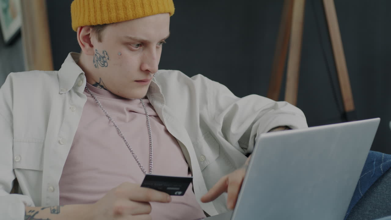 Young Man Shopping Online with Laptop and Credit Card