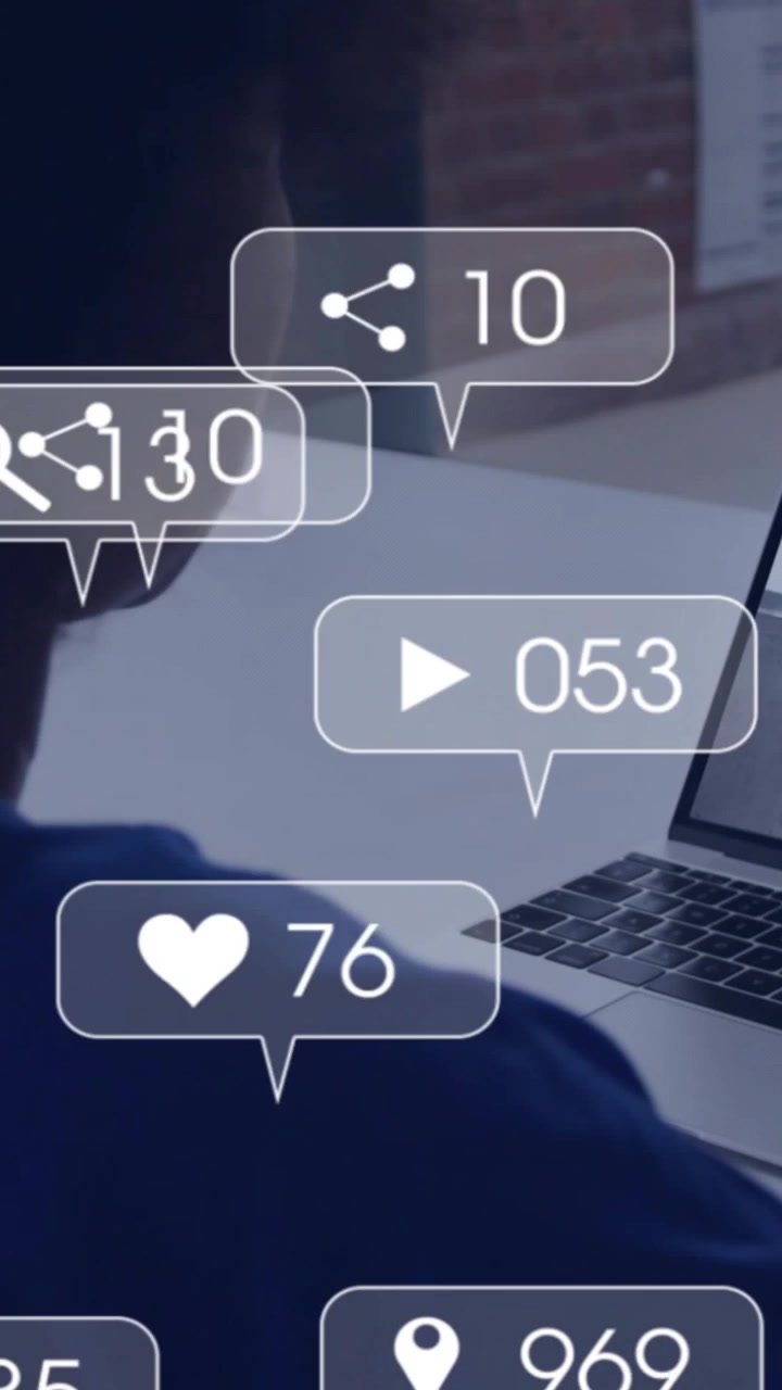 Vertical video: Woman tracking engagement at laptop as social alerts popping and updating metrics