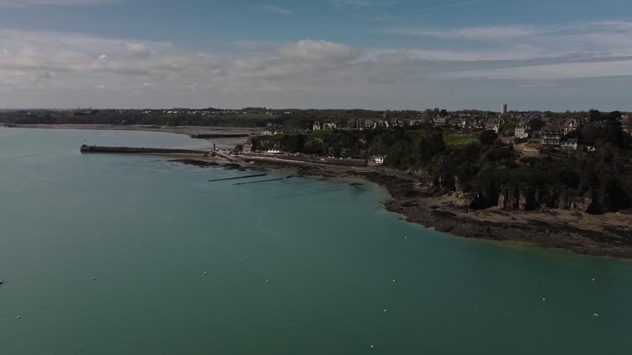 Riprese aeree 4K con drone di un grande allevamento di ostriche, Terrain de culture d‘huîtres, sulla spiaggia di Cancele, Bretagna, Francia. Il video inizia in mare e si dirige verso il fronte mare di un allevamento di ostriche