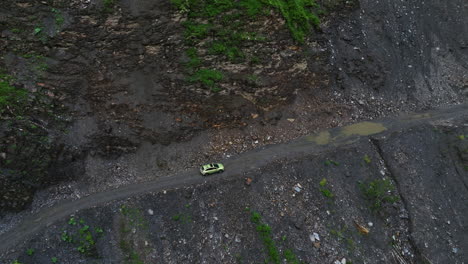 Vista-Aérea-De-Un-Automóvil-Que-Viaja-A-Través-Del-Paso-De-Montaña-Hacia-El-Pueblo-De-Ushguli-En-Svaneti,-Georgia