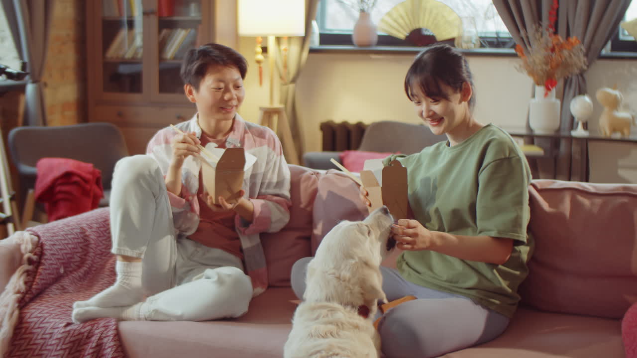 아시아 여성 들 이 집 에서 카드 상자 에서 음식 을 먹고 있다