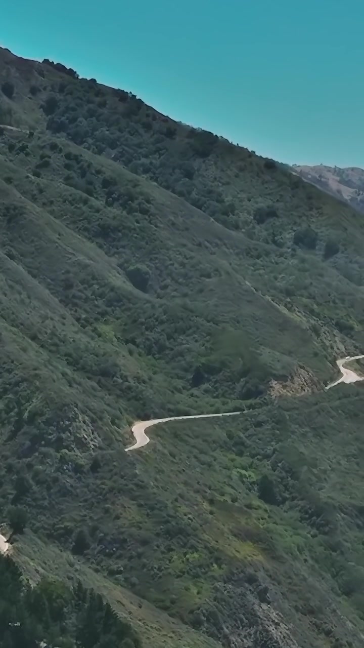 Vista aerea di una strada tortuosa sulle colline della California sotto un cielo sereno
