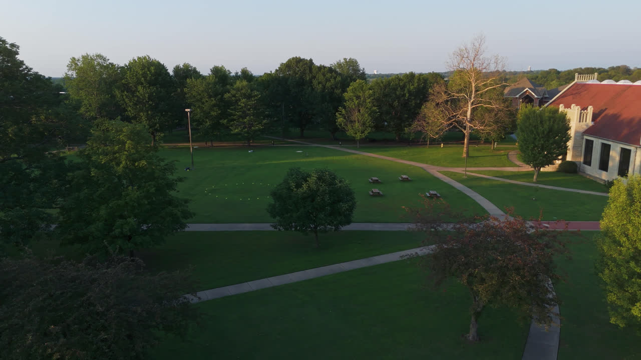 John Brown University Sign With US And Campus Flags In Siloam Springs, Arkansas, USA. - aerial shot