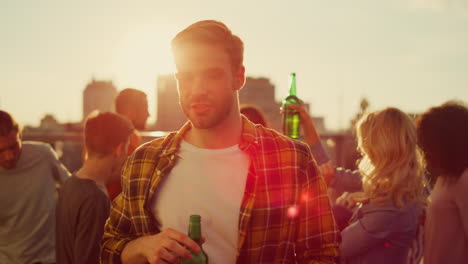 handsome man relaxing with bottle beer at party. happy guy dancing at disco.