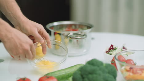 Closeup-chef-hands-cooking-eggs-with-wire-whiskers.