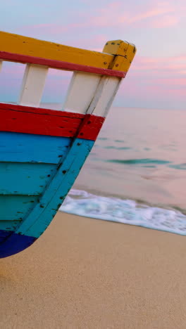 colorful wooden boat on a beach at sunrise/sunset