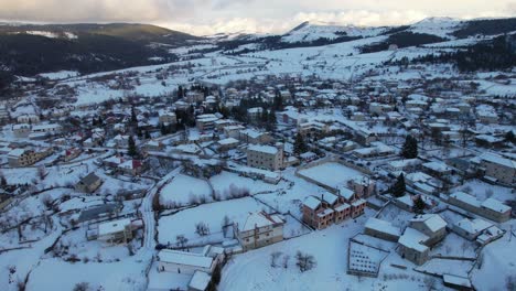 mountain village at winter with beautiful stone houses and guesthouses covered in snow, albania