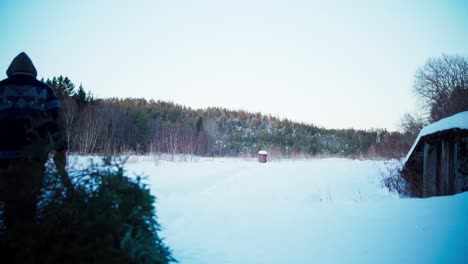 Mann-Zieht-Im-Winter-Geschnittene-Kiefer-Auf-Schnee