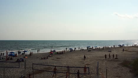 Youths-play-volleyball-on-the-sand-at-Folly-Beach,-South-Carolina