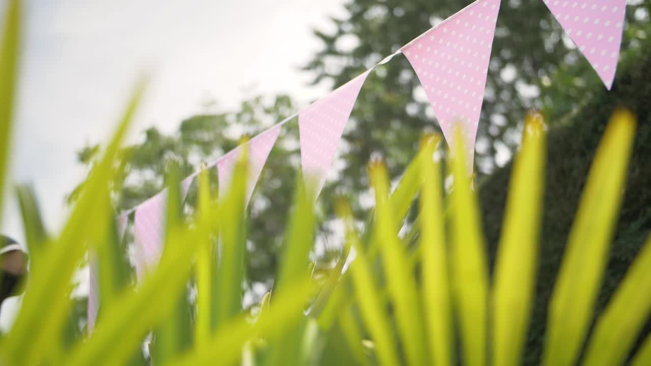 encantador triángulo rosa colgando banderas decoración en un jardín celebración de eventos en verano