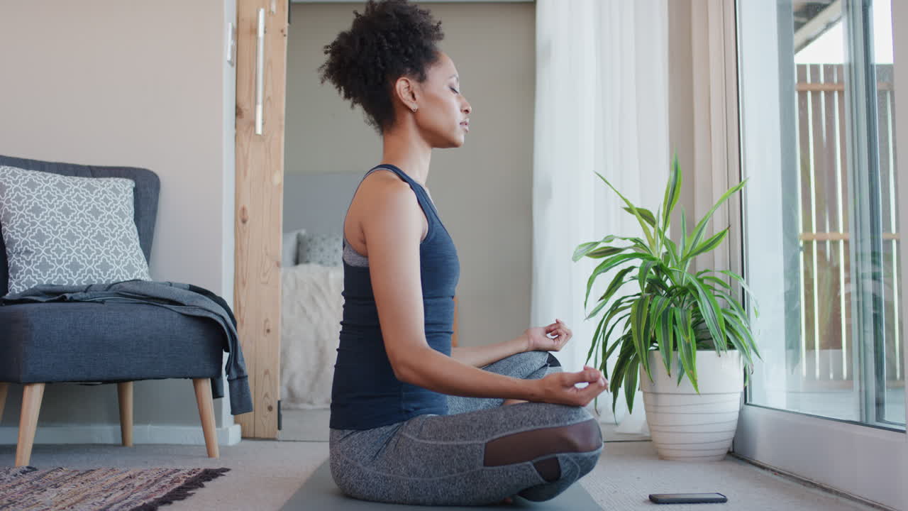 mujer de yoga saludable practicando meditación en la sala de estar disfrutando del ejercicio de atención plena por la mañana en casa