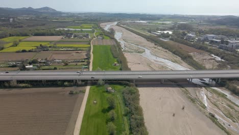 Aerial-dolly-left-shot-of-traffic-on-Spanish-highway-over-Tordera-River
