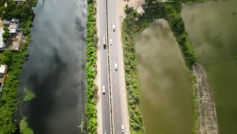 vehicles are moving from a beautiful road in dhaka city nearby a lake