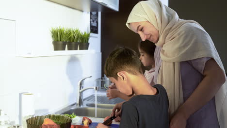 Close-up-view-of-mother-with-hiyab-and-childrens-in-the-kitchen.