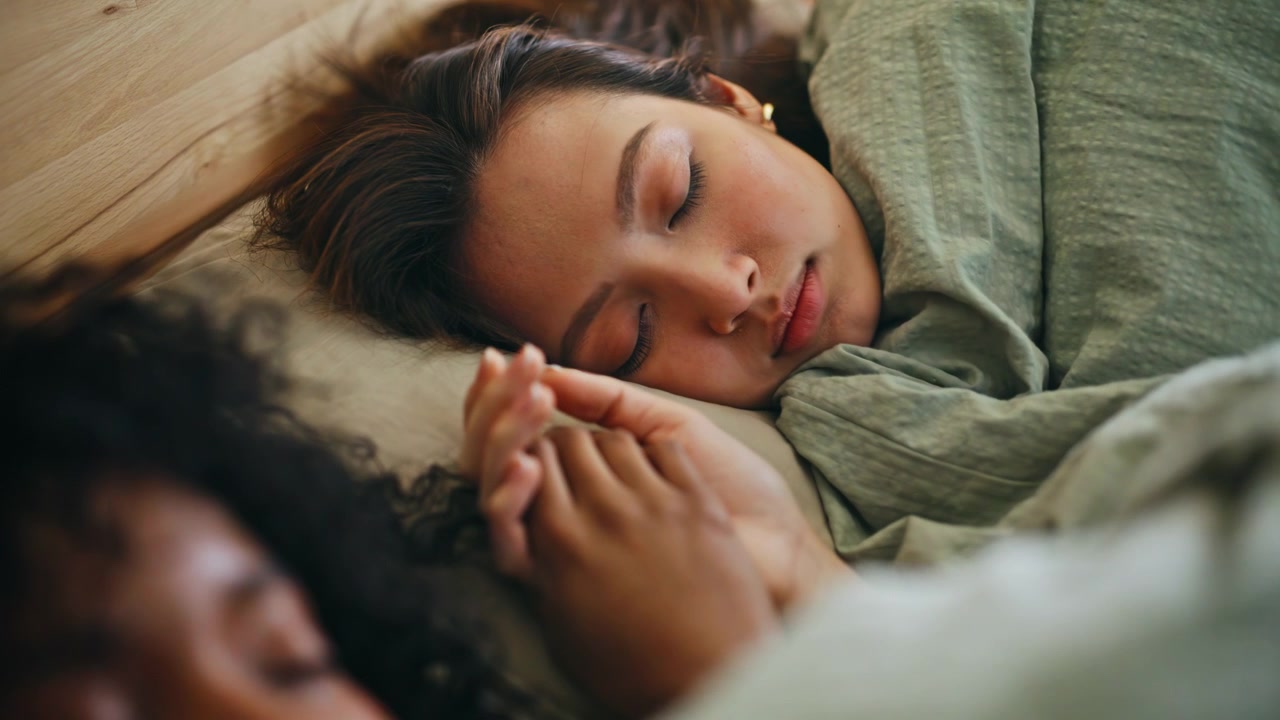 Lesbian couple holding hands bed. Closeup tender women resting together morning.