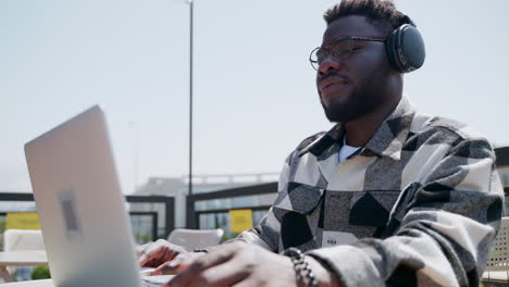 hombre trabajando en una computadora portátil al aire libre