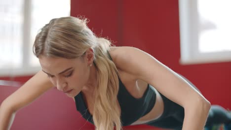 mujer de fitness empujando ejercicio en el suelo en el club deportivo. chica practicando en el gimnasio