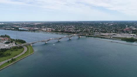 Die-Drohne-Nimmt-Aufnahmen-Von-Der-Fort-Erie-Friedensbrücke-Auf,-Während-Ein-Boot-Durch-Die-Gewässer-Des-Eriesees-Fährt