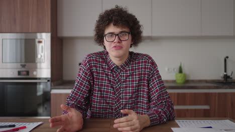 a man with glasses looking into the camera talks