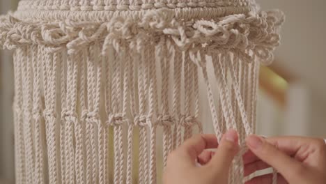 home hobby, knitting macrame. women's hands knit an ornament with thick threads.