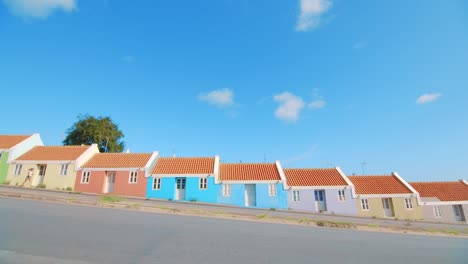 young girl walking past colorful houses on steep road in curacao, berg altena