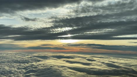 stunning clouded sky at sunset shot from a jet cabin while flying westbound at 12000m high, as seen by the pilots