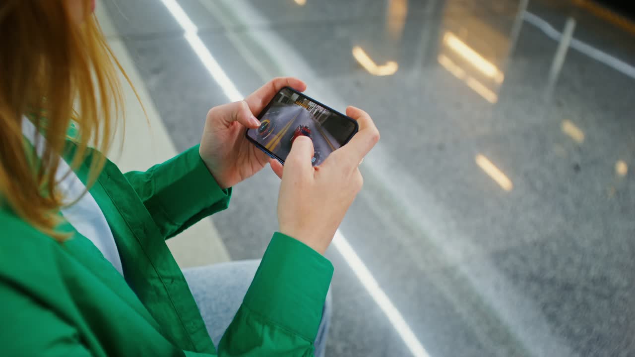 Woman Playing Racing Game on Mobile Phone