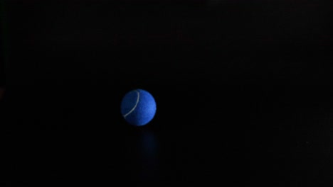 a tennis ball bouncing in dark background